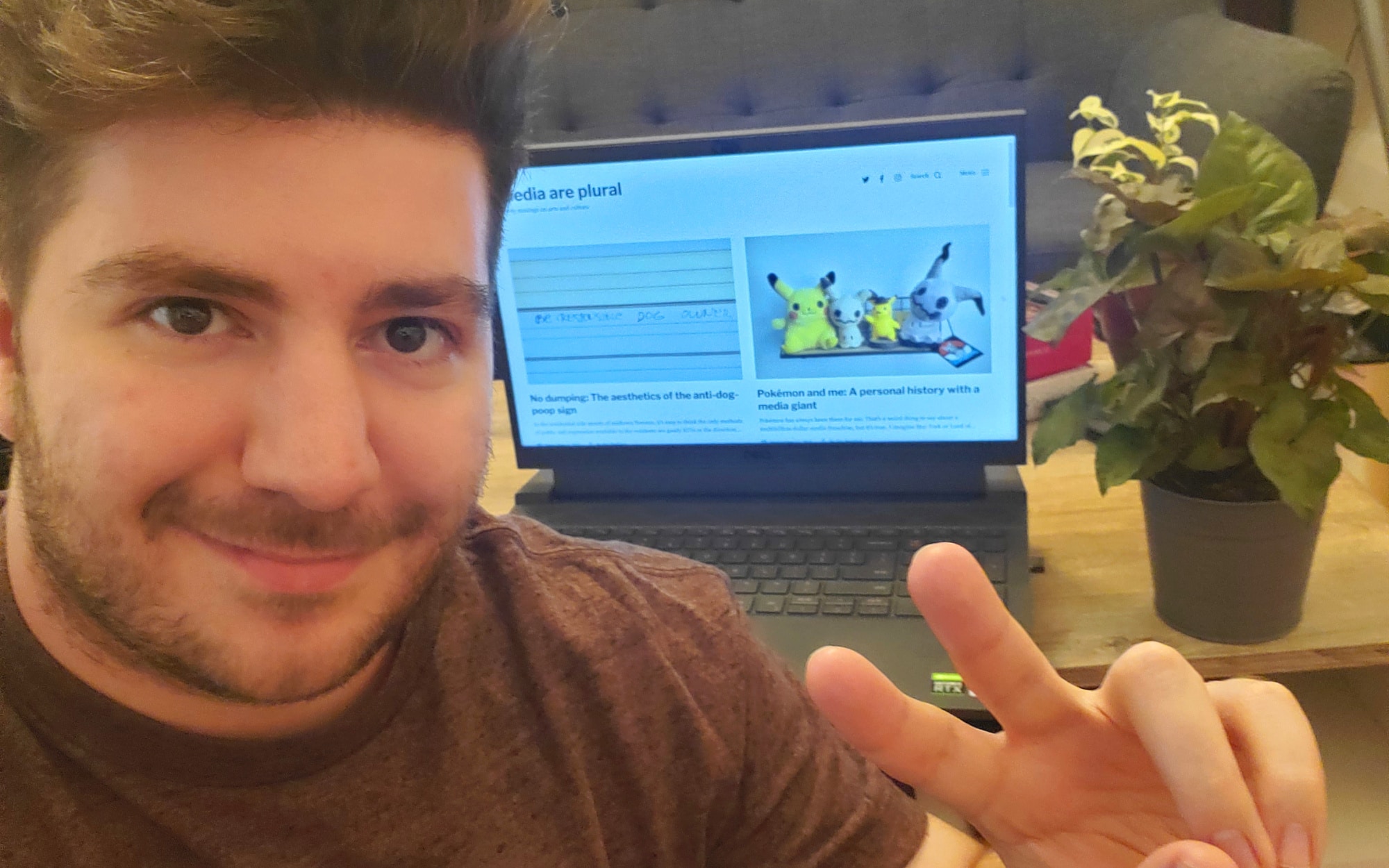 me taking a selfie with my blog pulled up on a computer beside me